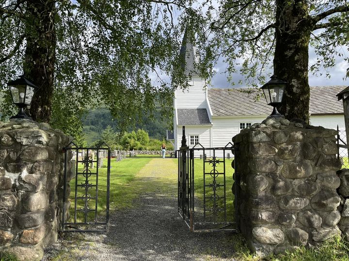 Porten til Stødle kyrkje med kyrkja i bakgrunnen.
